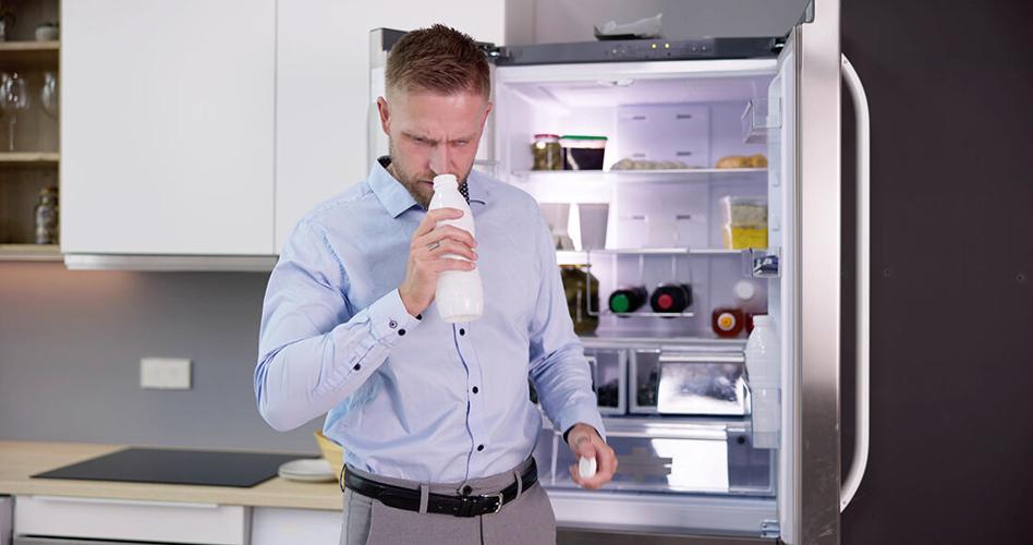 a man smells a bottle of milk